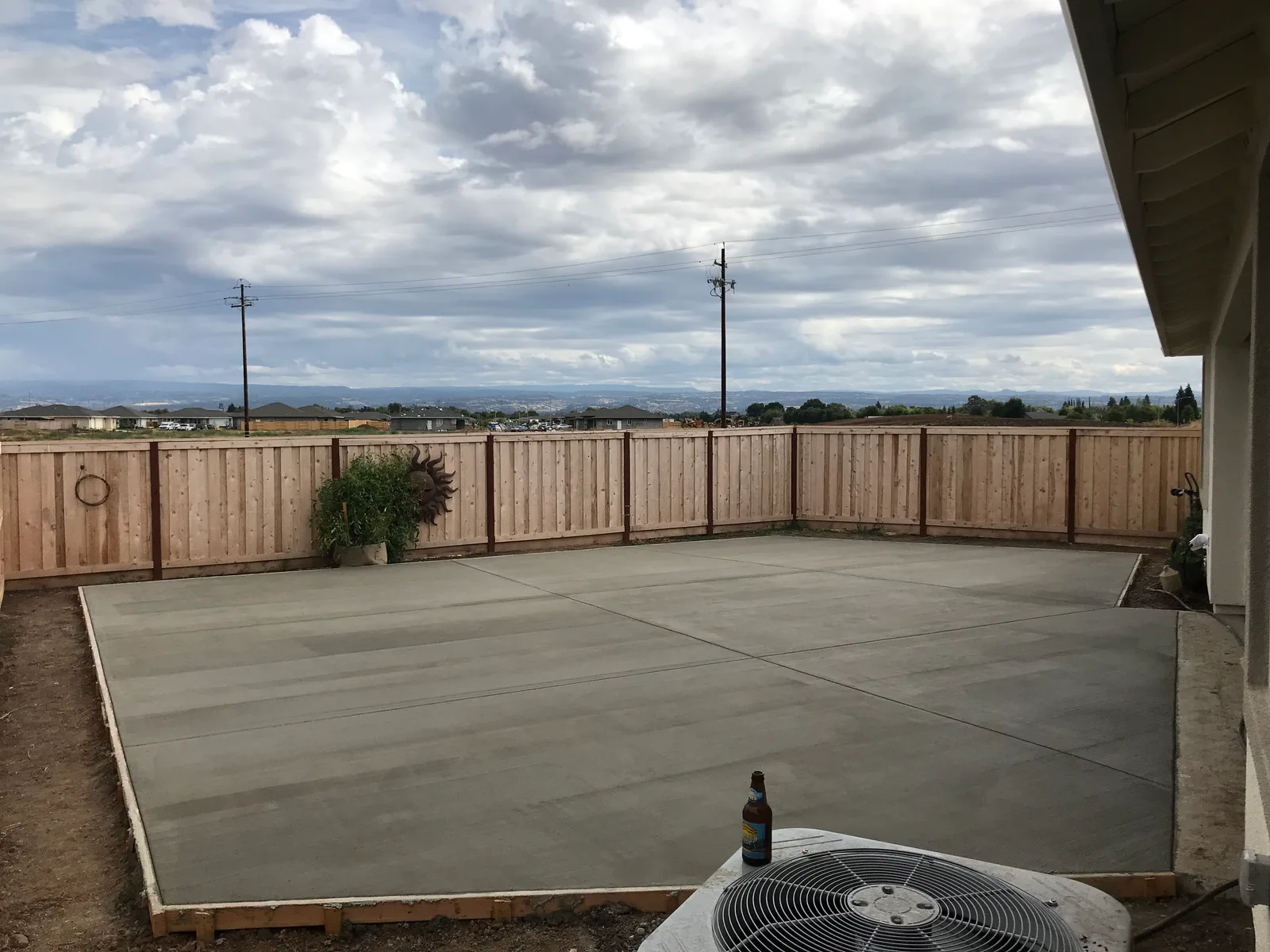 Freshly finished concrete patio in a fenced backyard
