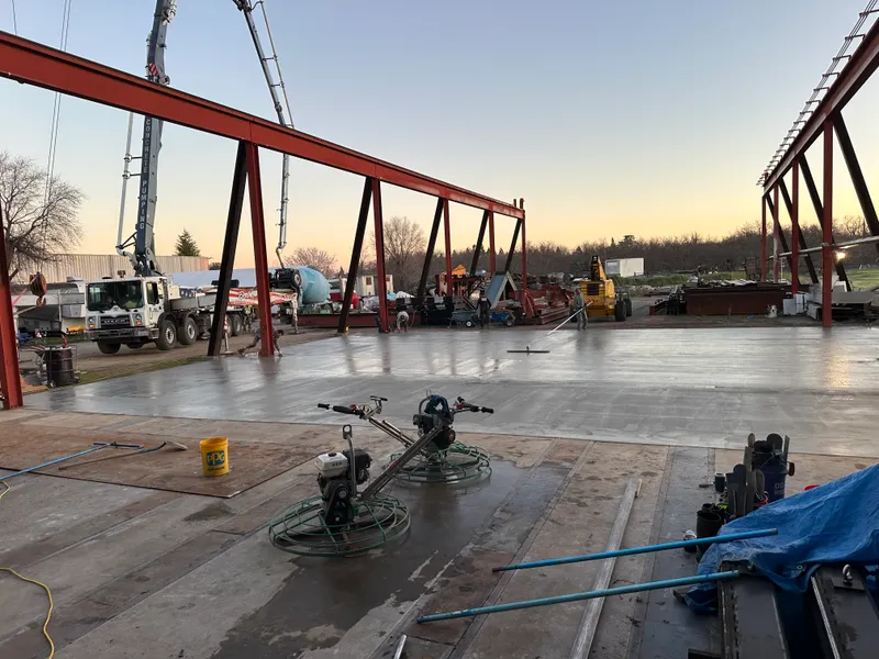 Concrete slab finishing inside a steel-framed commercial building