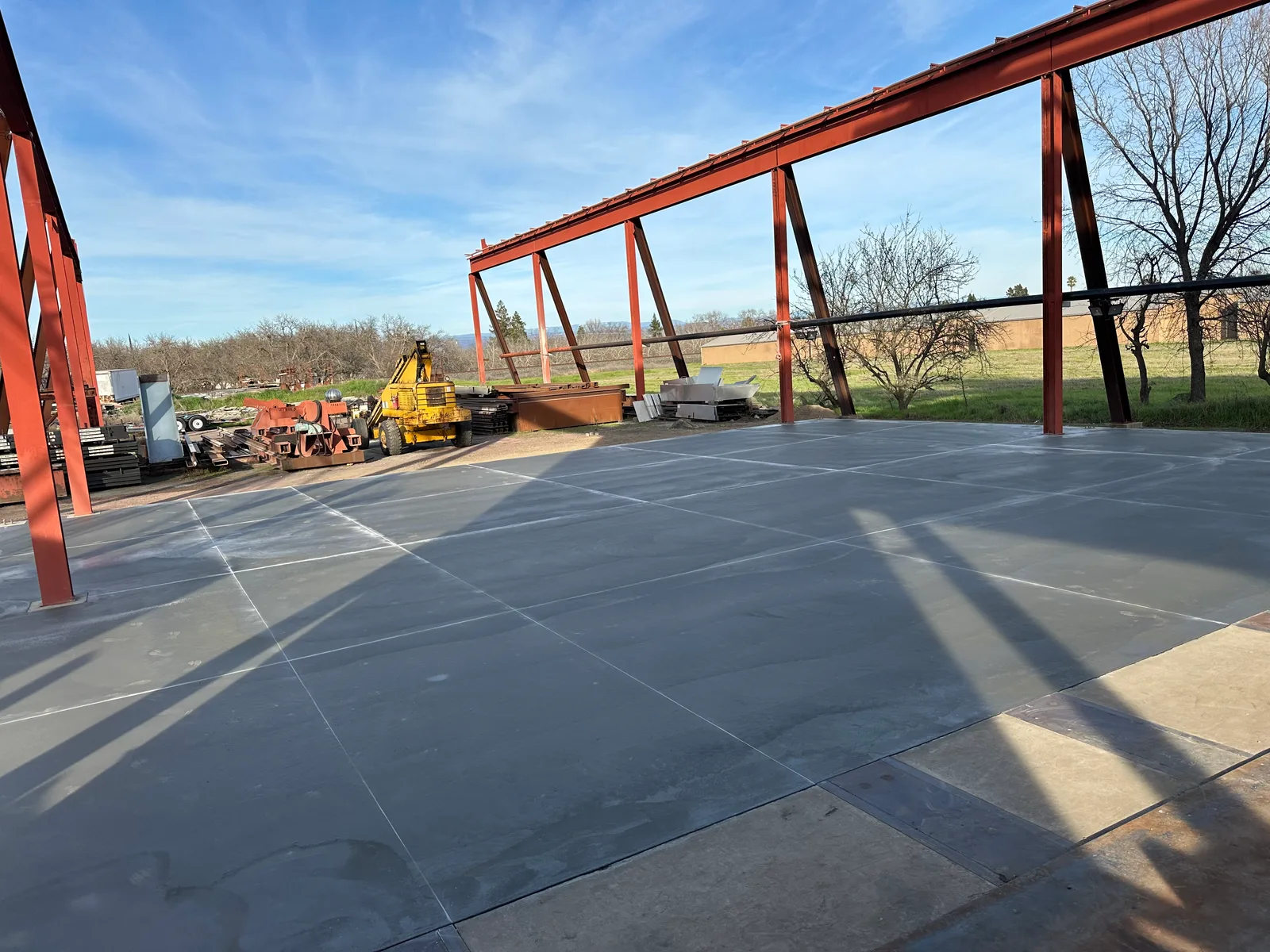 Finished concrete slab beneath a steel building frame